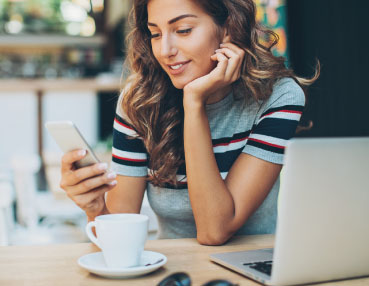 woman having coffee and checking her phone