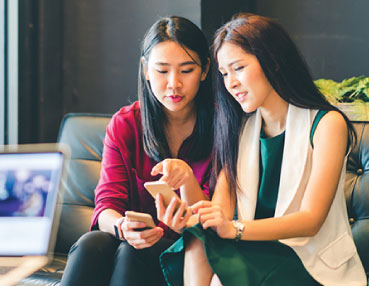 two women looking at something on a phone