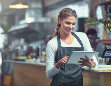 a woman at work checking something on a tablet 