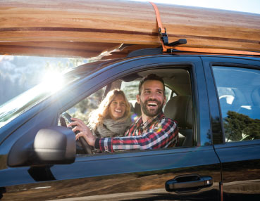 two people going on a trip in a new car