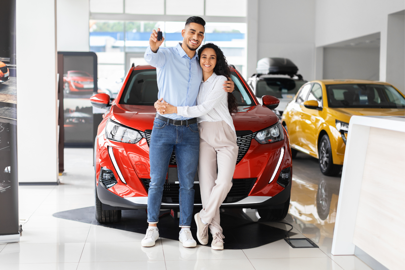 Young couple purchasing a new car, holding keys.