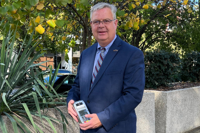 A photo of Jerry Hankins, Jr. holding a Credit Card Processing terminal.